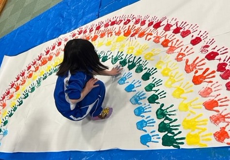 手形のスタンプを押す小学生